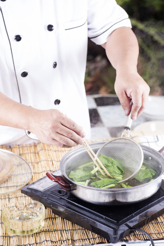 Chef scald vegetable in pot before cooking